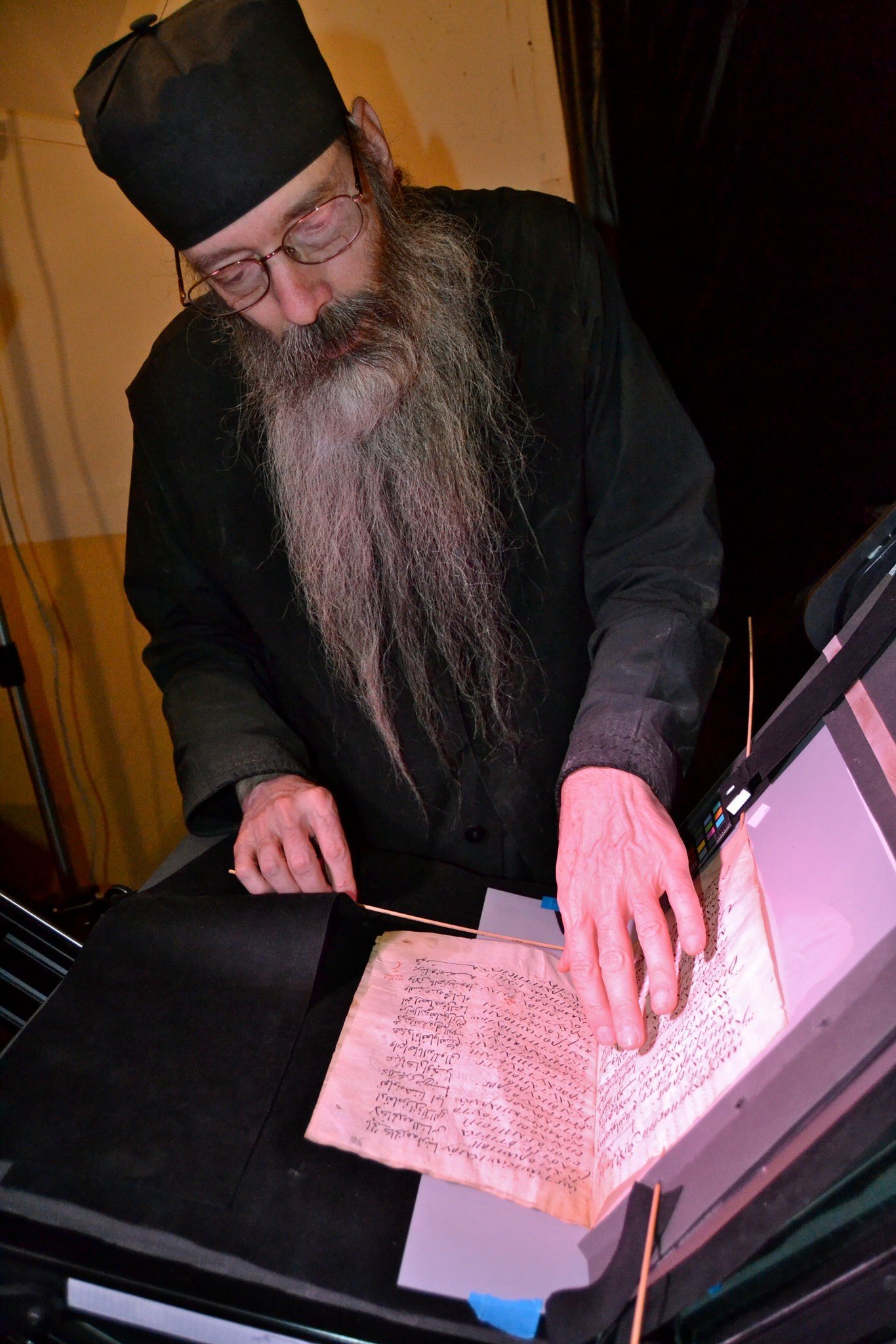 The librarian at St. Catherine's examining an ancient text.CreditMark Schrope