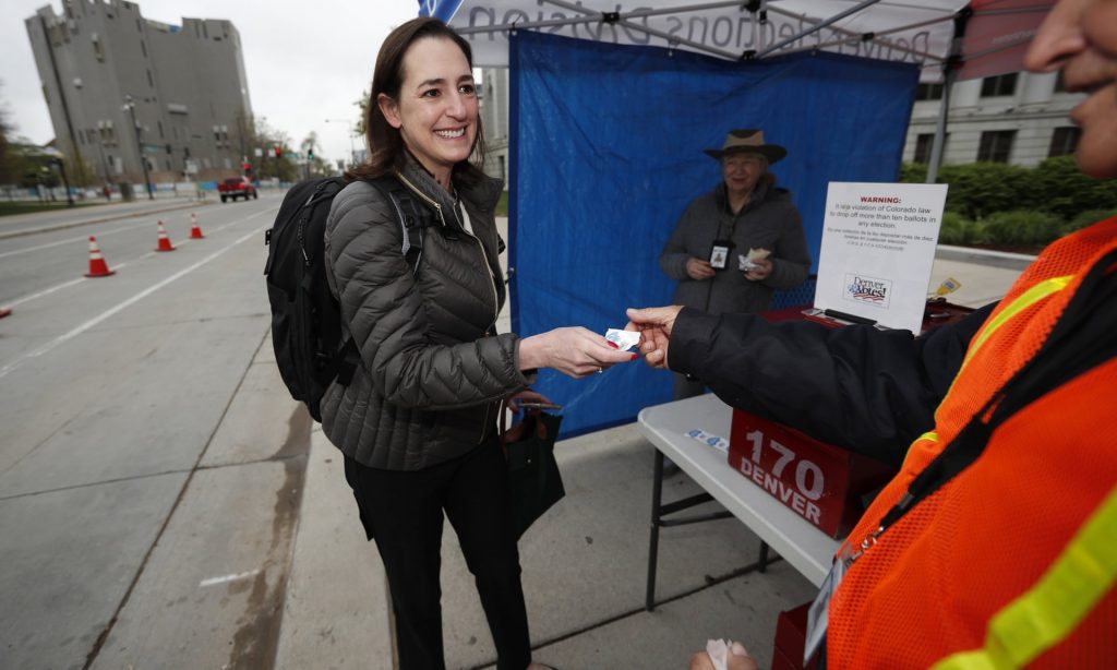 Nilufer Saltuk from Denver smiling as she receives a sticker after dropping off her ballot. Photograph: David Zalubowski/AP